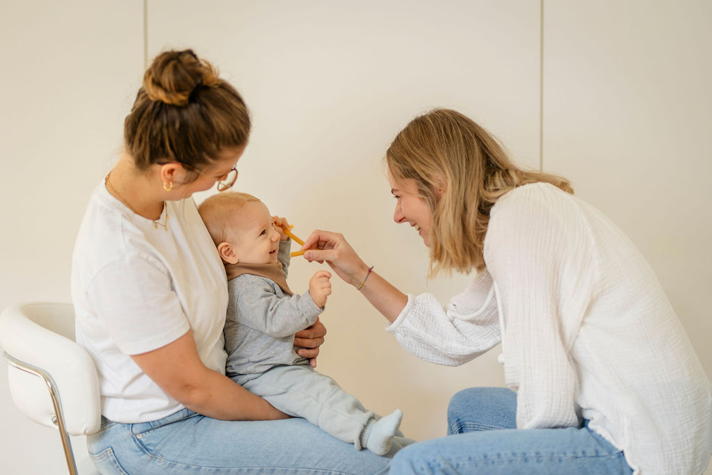 Logopädin spielt mit einem Baby während der Therapie